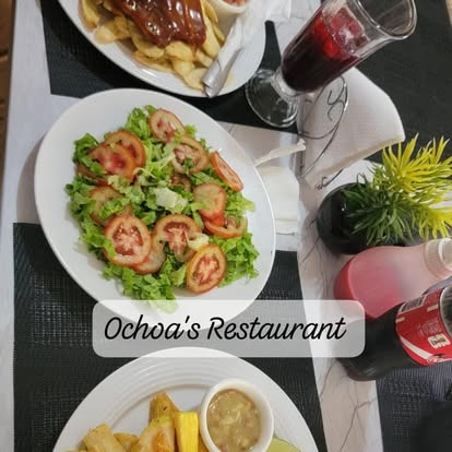 Mesa servida con ensalada, bebidas 
y comida